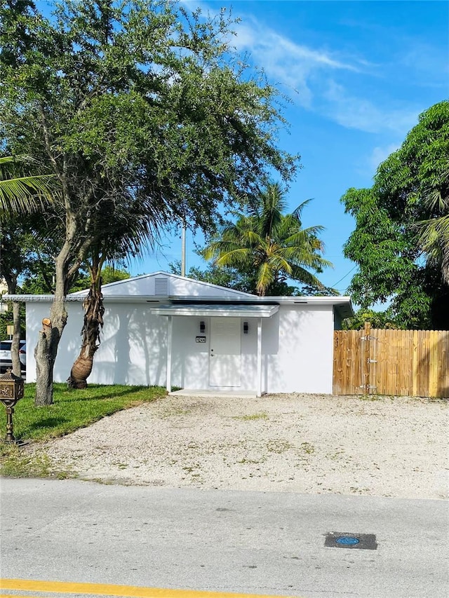 view of front of house with stucco siding and fence