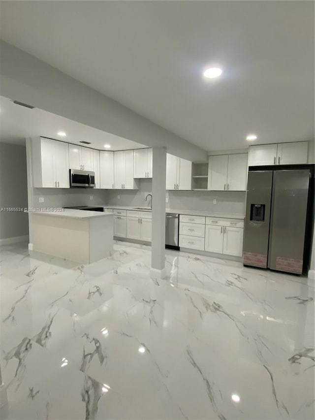 kitchen featuring appliances with stainless steel finishes, white cabinetry, and sink