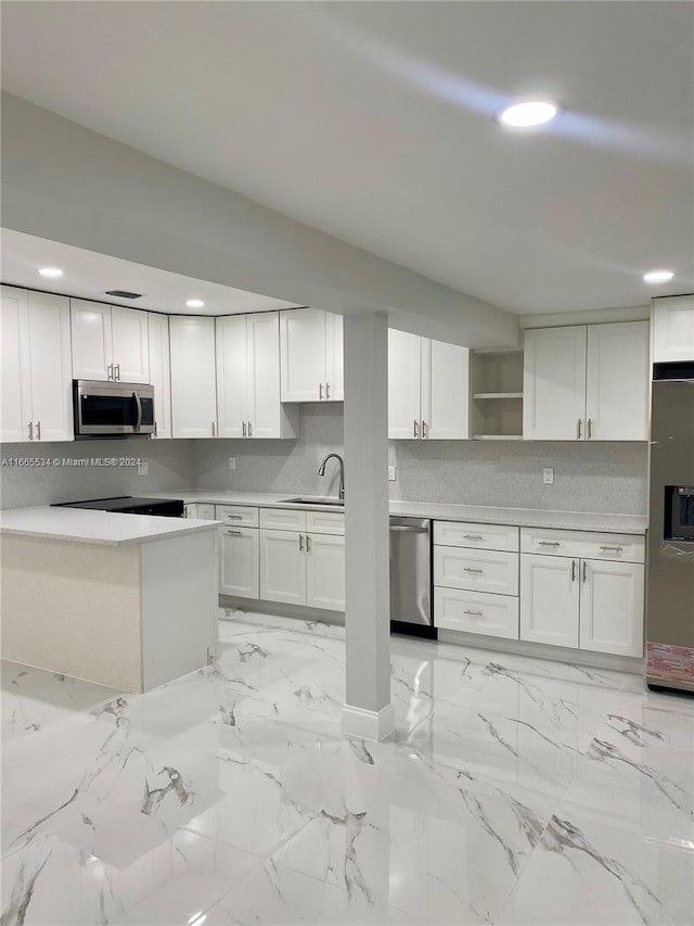 kitchen featuring decorative backsplash, white cabinetry, sink, and stainless steel appliances