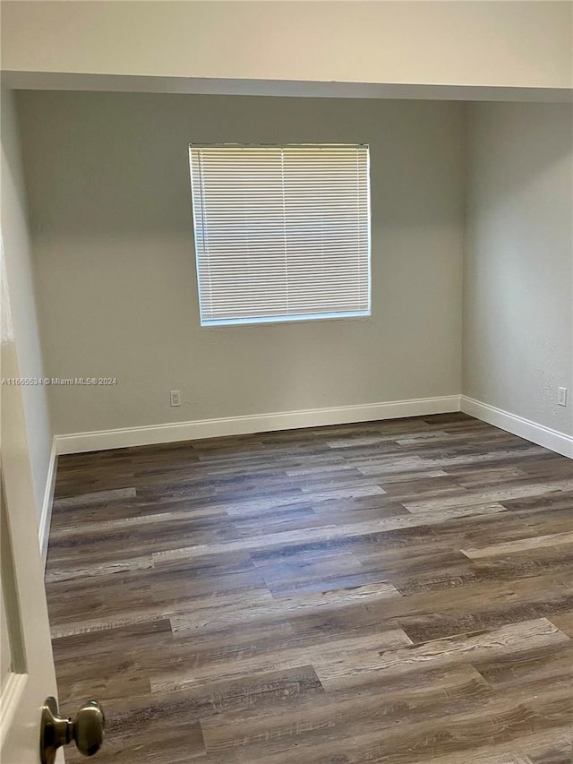 unfurnished room with dark wood-type flooring