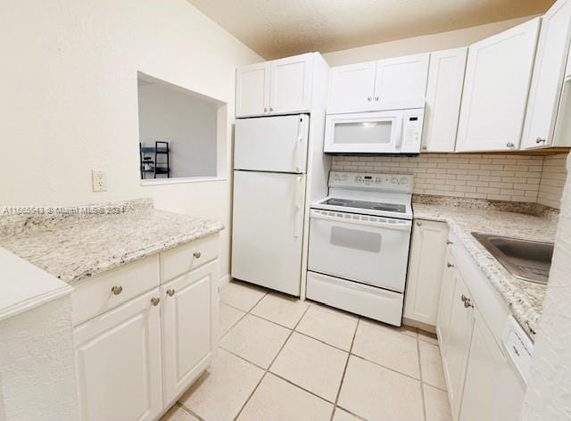 kitchen featuring tasteful backsplash, white appliances, and white cabinets