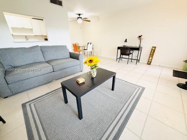 living room with ceiling fan and light tile patterned flooring