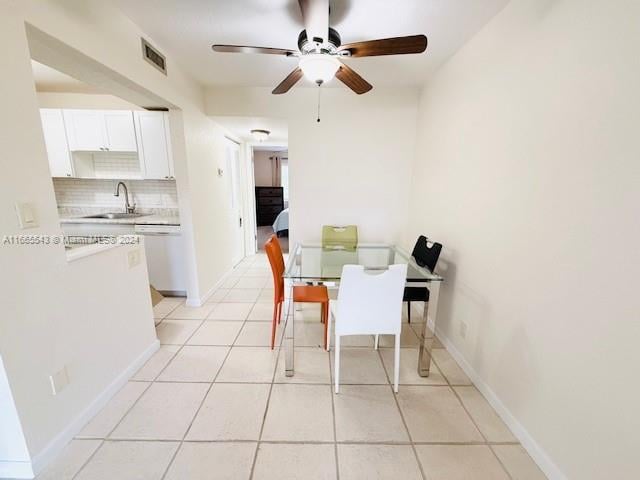 dining area with sink, light tile patterned floors, and ceiling fan