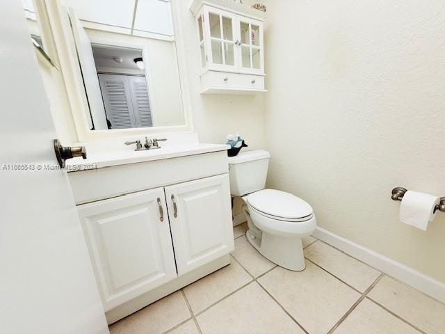 bathroom with toilet, vanity, and tile patterned floors