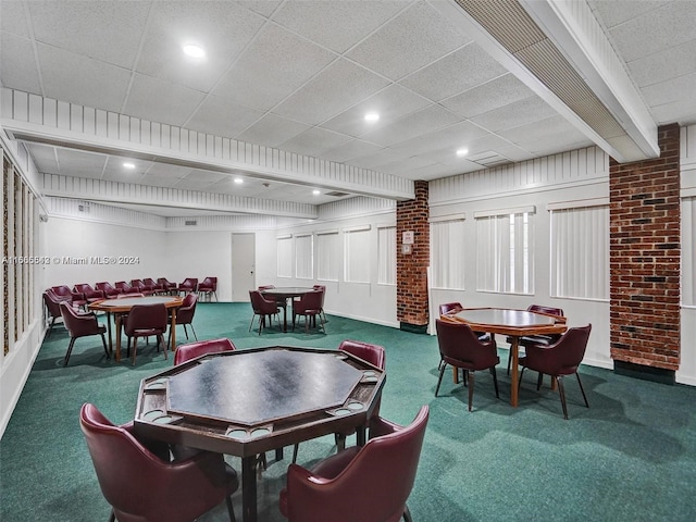 dining area with a paneled ceiling and carpet