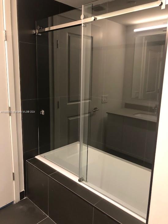 bathroom featuring a shower with shower door and tile patterned flooring