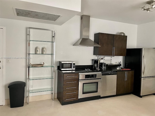 kitchen with dark brown cabinetry, wall chimney exhaust hood, sink, and stainless steel appliances