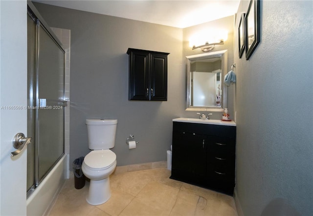 full bathroom with combined bath / shower with glass door, vanity, toilet, and tile patterned floors