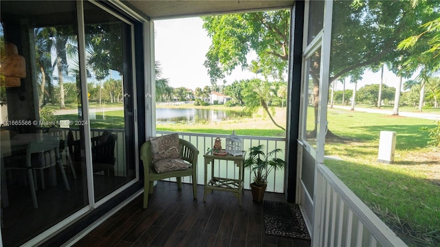 sunroom featuring a water view