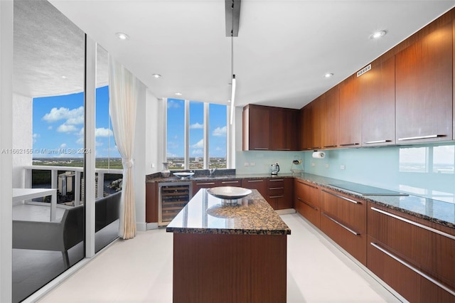 kitchen with black electric cooktop, dark stone countertops, wine cooler, a center island, and sink