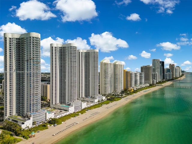 birds eye view of property with a water view and a beach view