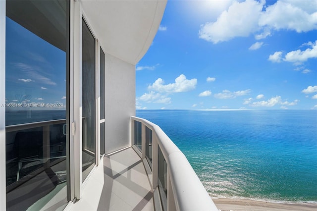 balcony featuring a beach view and a water view