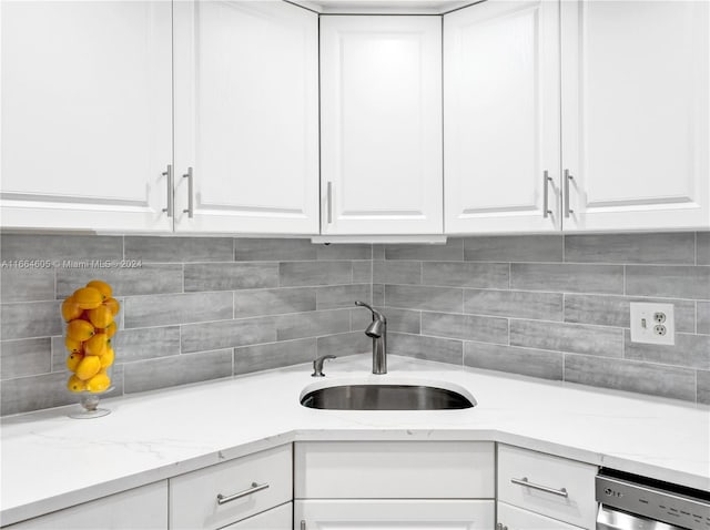 kitchen with dishwasher, sink, decorative backsplash, and white cabinetry