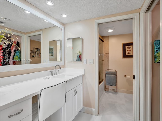 bathroom with a textured ceiling, vanity, and shower / bath combination