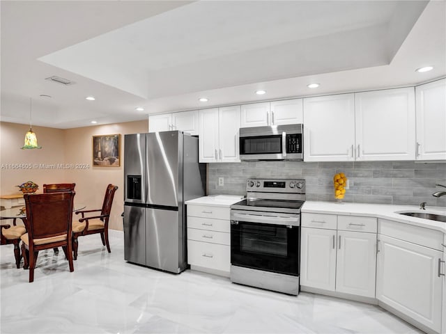 kitchen featuring stainless steel appliances, white cabinets, tasteful backsplash, and sink