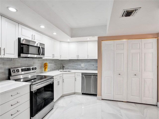 kitchen featuring backsplash, white cabinetry, sink, and stainless steel appliances