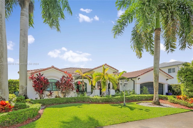 mediterranean / spanish home with a garage and a front yard