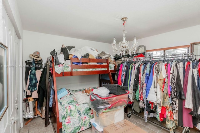 walk in closet with light tile patterned floors and a chandelier