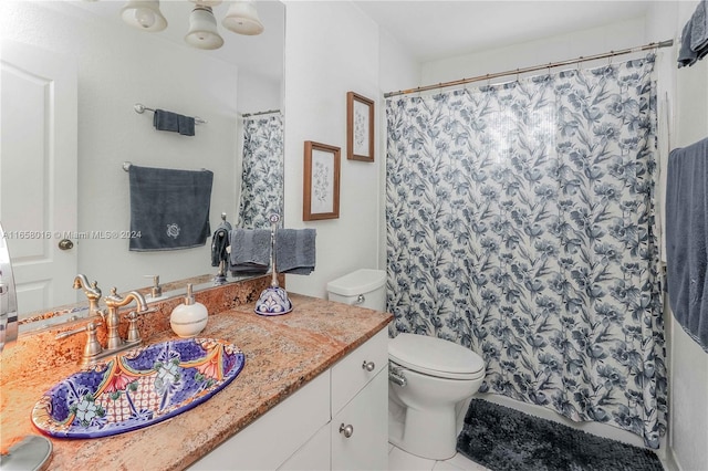 bathroom with a shower with curtain, vanity, tile patterned flooring, and toilet