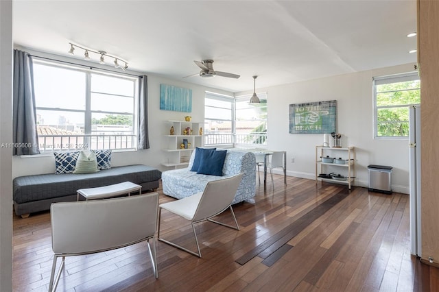 living room featuring a healthy amount of sunlight, dark hardwood / wood-style floors, and ceiling fan