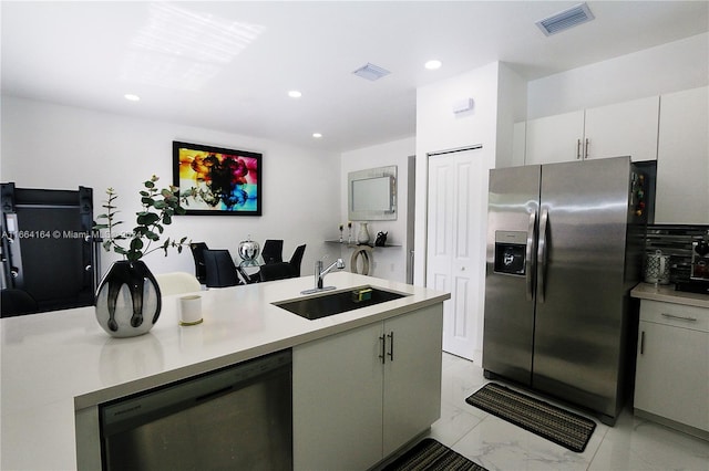 kitchen with appliances with stainless steel finishes, sink, and white cabinets