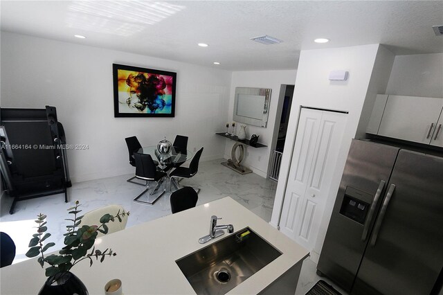 interior space with a textured ceiling and sink