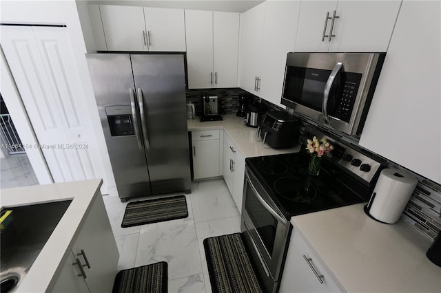 kitchen with white cabinets, backsplash, appliances with stainless steel finishes, and sink