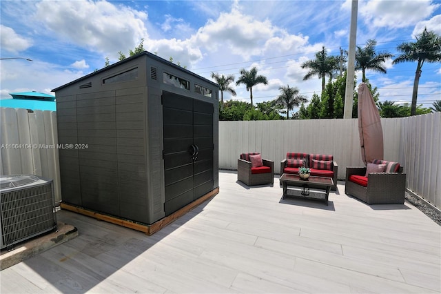 deck featuring a storage shed, cooling unit, an outdoor hangout area, and a patio area