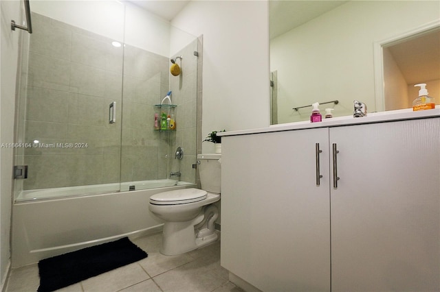 full bathroom featuring bath / shower combo with glass door, toilet, vanity, and tile patterned floors