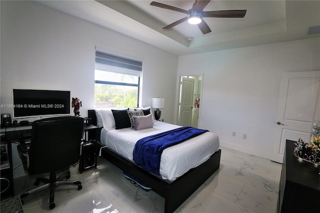 bedroom with ceiling fan and a raised ceiling