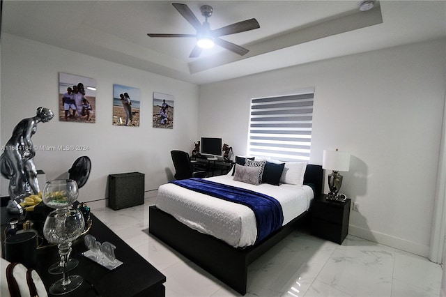 bedroom featuring ceiling fan and a raised ceiling