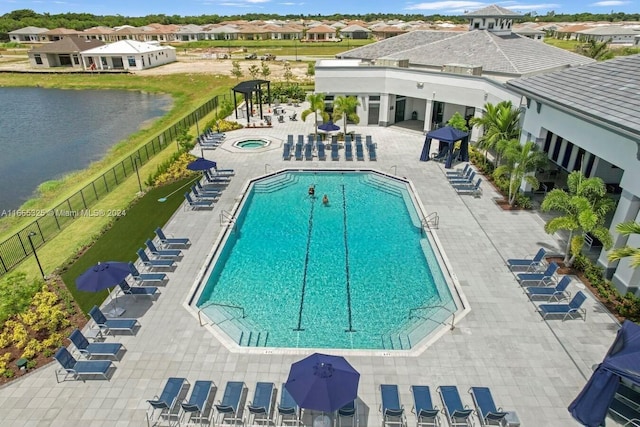 view of pool featuring a water view and a patio