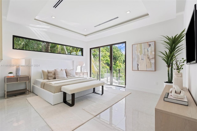 bedroom with access to outside and a raised ceiling