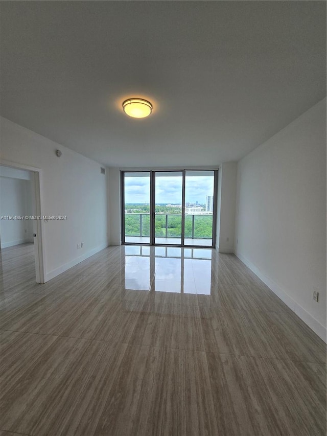 spare room featuring hardwood / wood-style floors and floor to ceiling windows