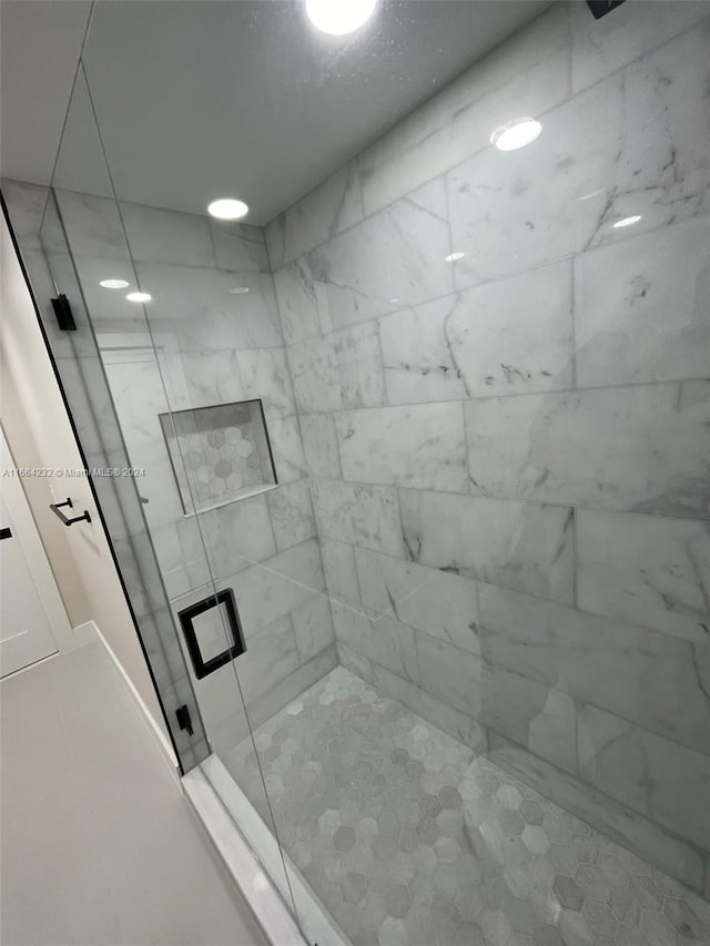 bathroom featuring a shower with shower door