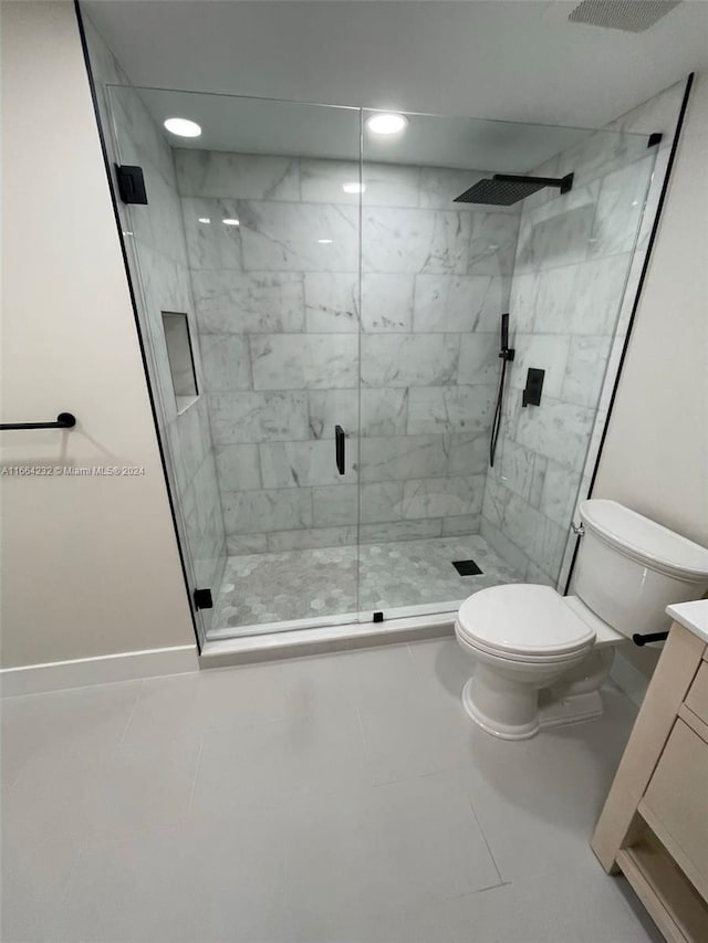 bathroom featuring vanity, a shower with shower door, toilet, and tile patterned floors