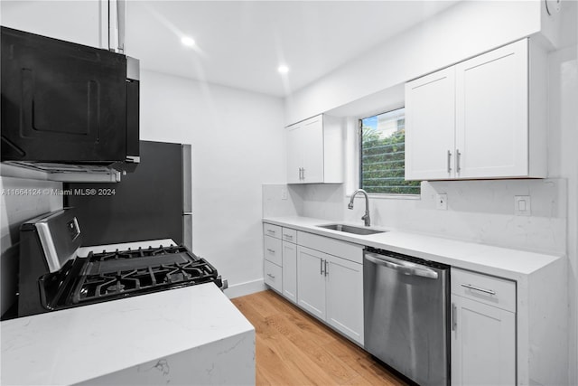 kitchen featuring light hardwood / wood-style floors, sink, white cabinets, gas range, and stainless steel dishwasher