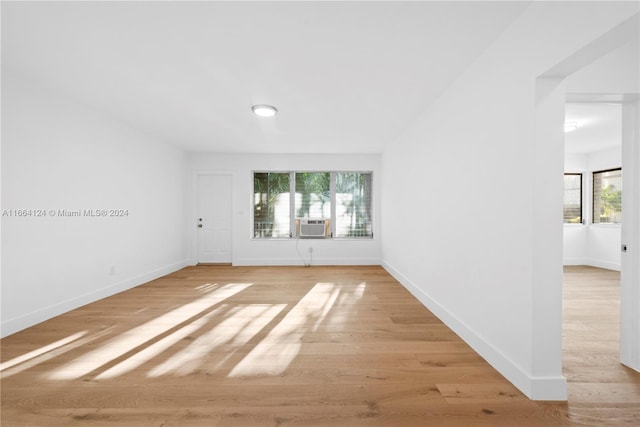 spare room with cooling unit, light hardwood / wood-style flooring, and a wealth of natural light