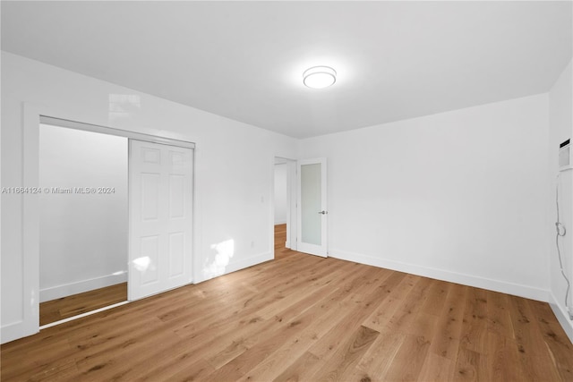 unfurnished bedroom with light hardwood / wood-style flooring and a closet