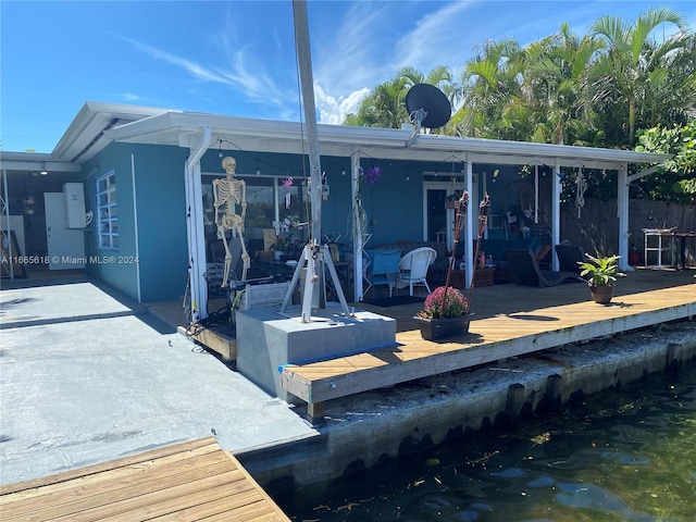 rear view of property with a wooden deck and a patio