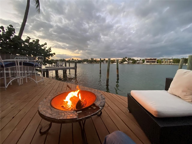 dock area with a water view and a fire pit