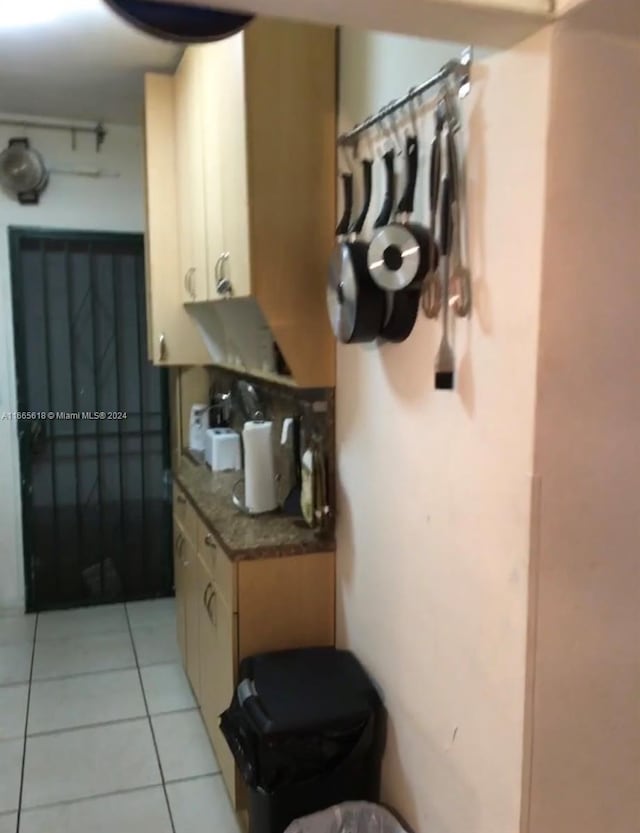 kitchen with dark stone counters and light tile patterned flooring