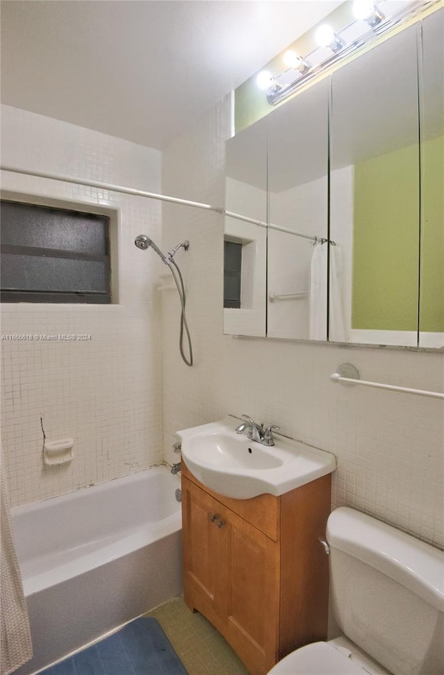 full bathroom with vanity, shower / tub combo, tile patterned floors, tile walls, and toilet