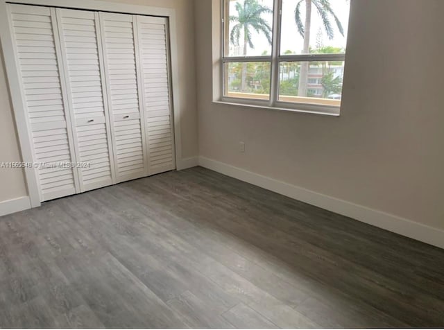 unfurnished bedroom with wood-type flooring and a closet