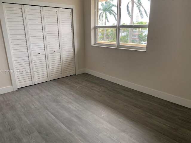 unfurnished bedroom with hardwood / wood-style flooring and a closet