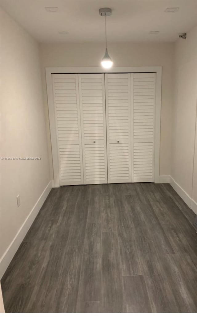 unfurnished bedroom with dark wood-type flooring