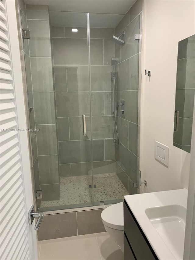 bathroom featuring tile patterned floors, an enclosed shower, vanity, and toilet