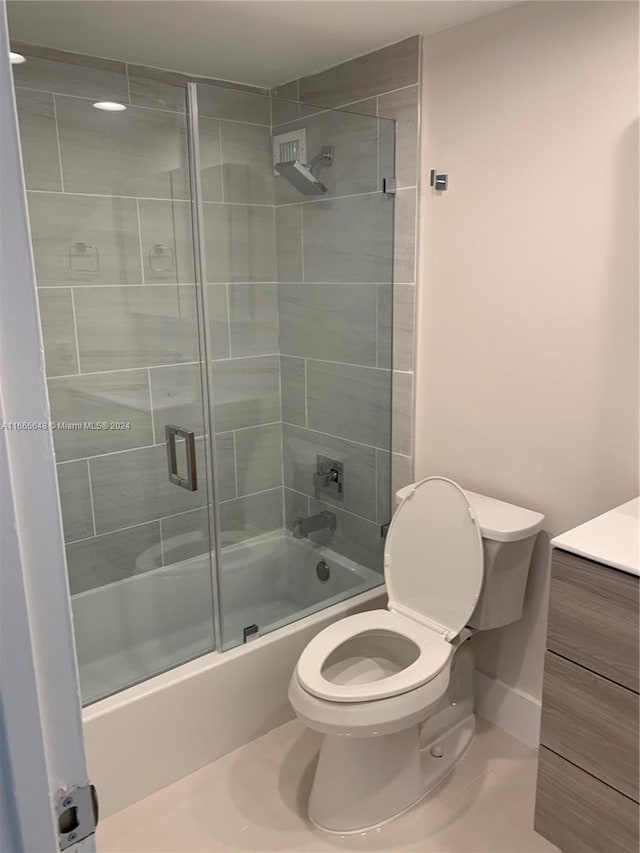 full bathroom featuring bath / shower combo with glass door, vanity, and toilet