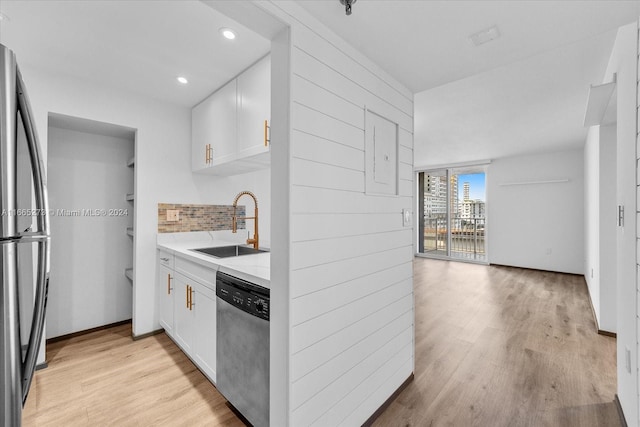 kitchen with white cabinets, sink, tasteful backsplash, stainless steel appliances, and light hardwood / wood-style floors