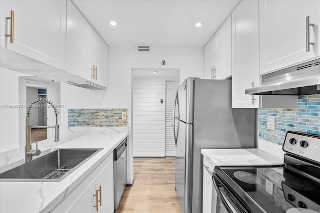 kitchen with black range with electric stovetop, light wood-type flooring, sink, and white cabinetry